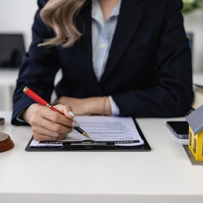 une femme en train de signer un mandat immobilier