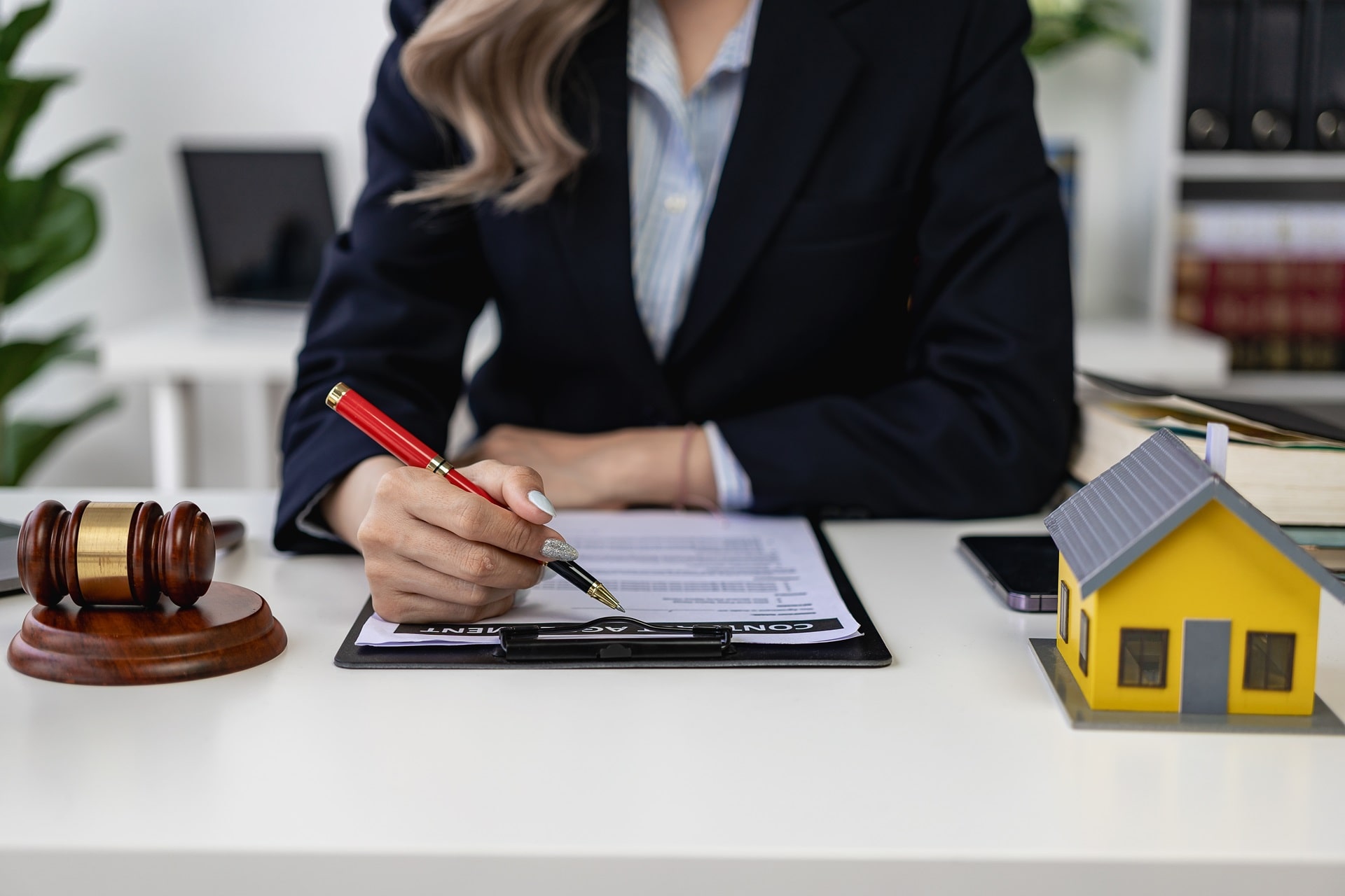 une femme en train de signer un mandat immobilier